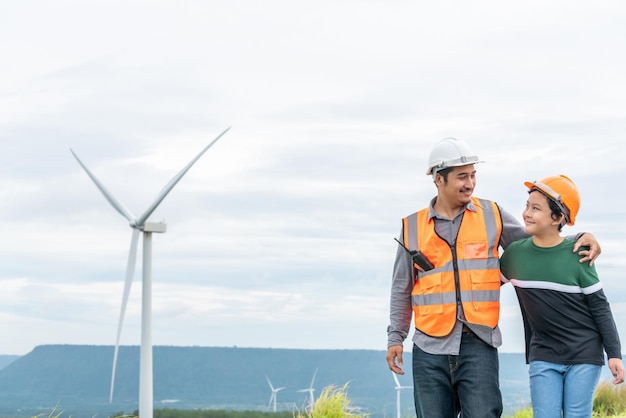 Progressive engineer with his son in the wind farm atop of the mountain