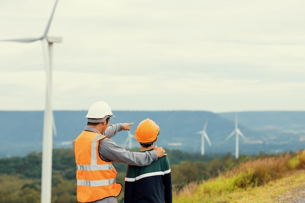 Progressive engineer with his son in the wind farm atop of the mountain