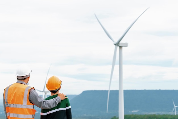 Progressive engineer with his son in the wind farm atop of the mountain