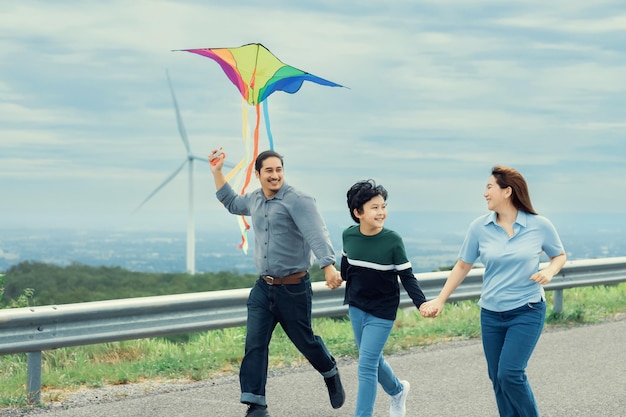 Progressive happy carefree family vacation concept flying kite with wind turbine