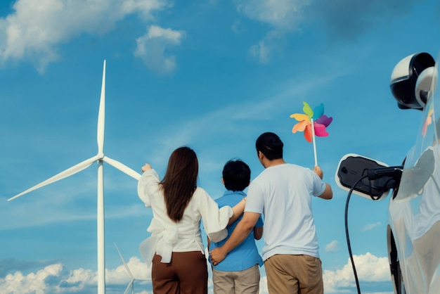 Progressive happy family enjoy their time at wind farm for green energy concept