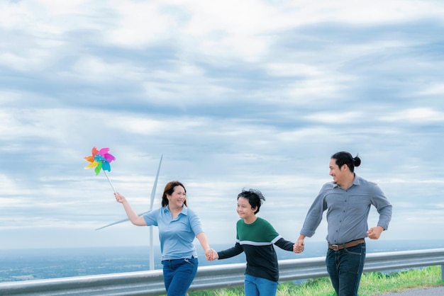 진보적인 행복한 가족은 친환경 에너지 개념을 위해 풍력 발전소에서 시간을 즐깁니다.