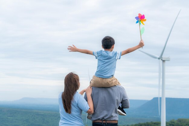 Progressive happy family enjoy their time at wind farm for green energy concept