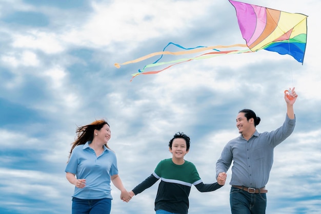 Progressive happy family vacation concept with outdoor flying kite on the road