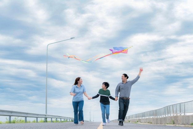 Progressive happy family vacation concept with outdoor flying kite on the road