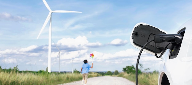 Progressive young asian boy playing with wind pinwheel toy at wind turbine farm