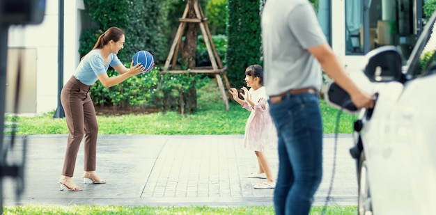 Progressive young happy family living in a home with an electric car