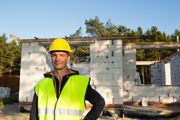 Photo project architect stands near construction site of a house with the wall