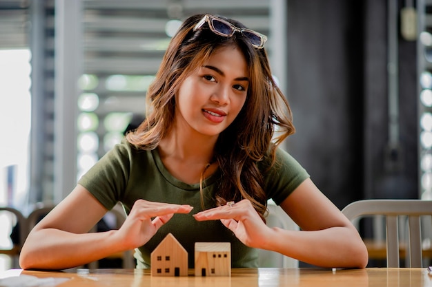 Проектные дома наличные кредиты и жилые дома Молодая женщина с модельным деревянным домом