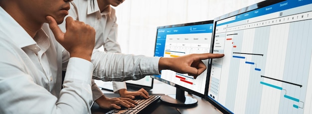Project management team coordinating and update project planned schedule on computer using Gantt chart software in office Business people planning time and deadline for company task Trailblazing