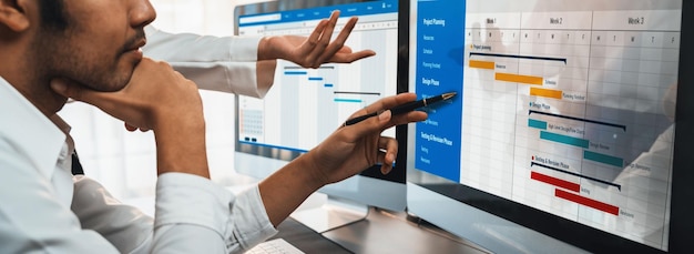 プロジェクト管理チームがオフィスのガント チャート ソフトウェアを使用してコンピューター上でプロジェクトの計画スケジュールを調整および更新するビジネスマンが会社のタスクの時間と期限を計画する