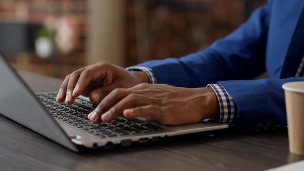 Project manager developing business charts on laptop to plan strategy, using paperwork report with statistics on internet app. Company employee working on online website. Close up.