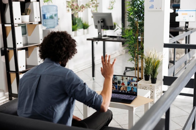 Photo project manager greeting group of coworkers during virtual meeting