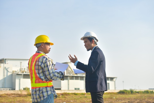 Project Manager taking with Engineer construction plan project building factory construction