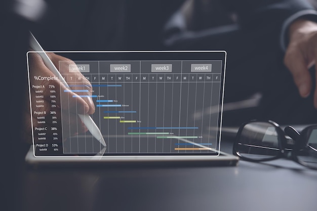 Foto project manager che lavora e aggiorna le attività con la pianificazione dello stato di avanzamento delle pietre miliari e la pianificazione del diagramma di gantt