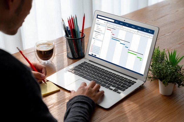 写真 チームプロジェクトのタイムラインチャートを表示するコンピューター画面上の現代的なビジネスプロジェクト管理用のプロジェクト計画ソフトウェア
