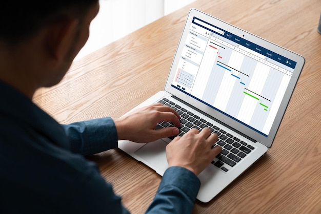 Foto software di pianificazione del progetto per la gestione del progetto aziendale modish sullo schermo del computer che mostra il grafico della linea temporale del progetto del team