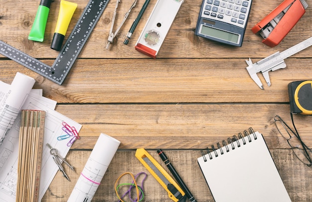 Projectbouwblauwdrukken en technische hulpmiddelen op houten bureau kopieerruimte