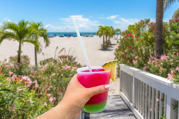 Promenade op strand in St Pete met Hand die een glas met cocktail en stro vasthoudt Florida de V.S