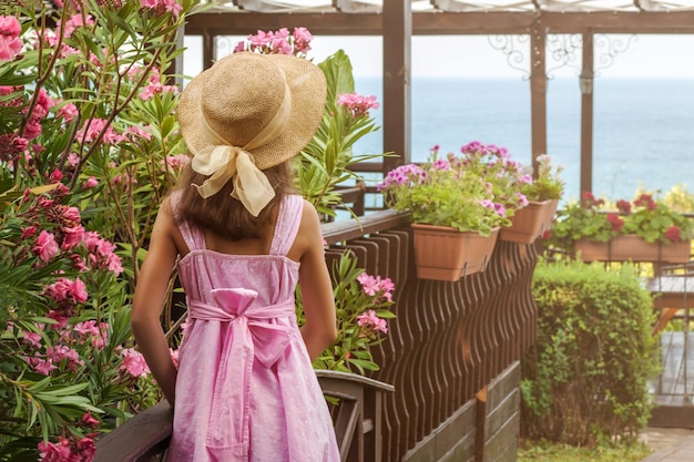 Promenade of Sea coast Traveller Girl Teen enjoys Sea view and flowers in summer time