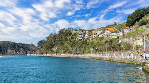 Ribadesella Asturias 마을의 바다 옆 그림 같은 가로등 기둥과 다채로운 집이 있는 산책로