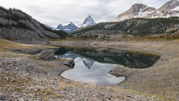 小さな谷の高山湖に反射する顕著なピークmtassiniboinepr park canada