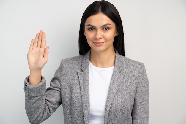 Promise to tell truth. Portrait of woman raising hand to take oaths, promise to speak only truth, be sincere and honest, trustworthy evidence. Studio shot isolated on white background