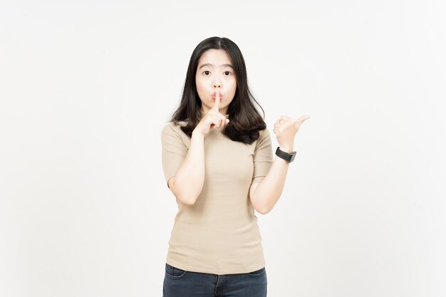 Promo pointing side product and finger on lips Of Beautiful Asian Woman Isolated On White Background