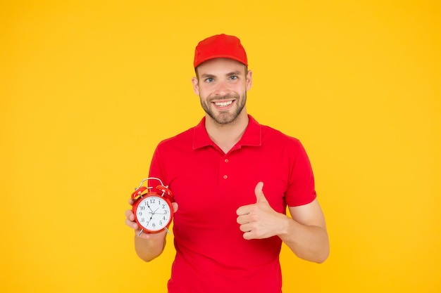 Promptness and punctuality Delivery time Delivery courier with clock Delivery man holding clock Shipping services Post office Online shopping Will deliver at agreed time Timeliness guarantee