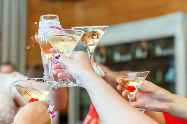 Proost. Groep mensen drinken en roosteren in restaurant. Handen met glazen champagne en wijn die toast maakt. Kerst nieuwjaar bruiloft vakantie feest tijd. Viering en nachtleven concept.