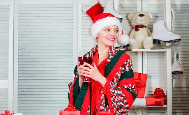 Proost kerstavond concept meisje in kerstmuts klaar om te voldoen aan nieuwjaar kerst toast vrouw met wijnglas vieren wintervakantie kerst gezellig huis vrouw vieren kerst thuis