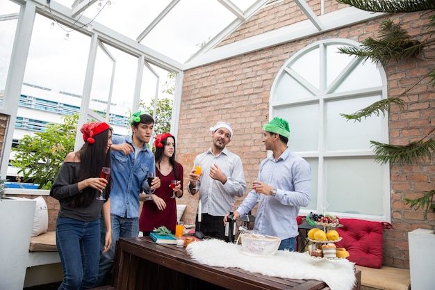 Proost op beste vrienden, vrolijke jonge mensen die juichen met champagnefluiten en er gelukkig uitzien