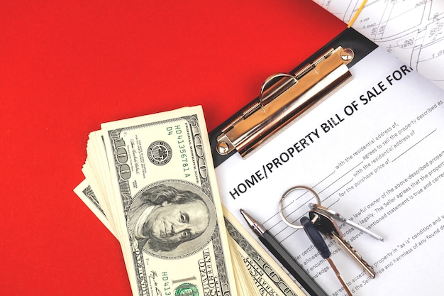 Property bill of sale form. house keys, money and real estate project documents. office table top view photo