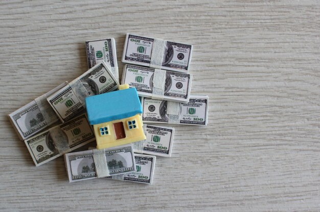 Property investment and house mortgage concept Top view image of house on top of pile of money