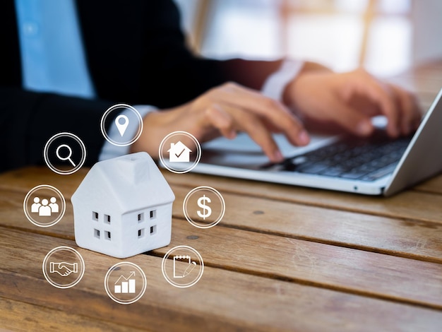 Valore della proprietà investimento domestico mercato immobiliare online e concetti di selezione della casa diagramma di valutazione della proprietà con icone virtuali vicino alla casa in miniatura bianca con uomini d'affari che utilizzano il laptop