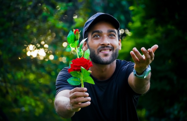 Proponendo alla sua ragazza un uomo con una bella rosa rossa che dà alla ragazza e dà la sua mano