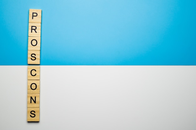 Фото Слово «за и против» в деревянном блоке на цветной поверхности дуэта