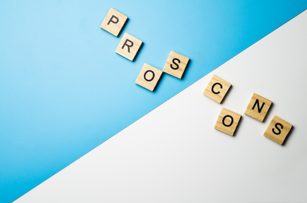 "Pros and Cons" word in the wooden block on duo color surface