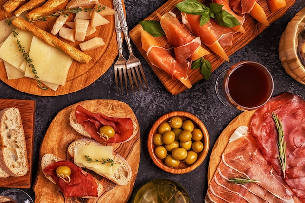 Prosciutto, cheese and olives on wooden boards
