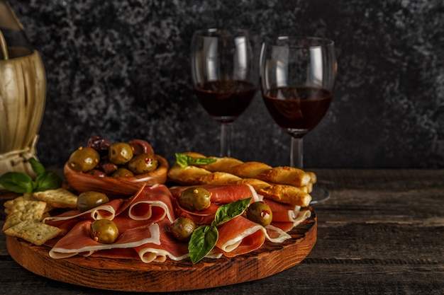 Prosciutto, cracker, bread sticks with red wine.