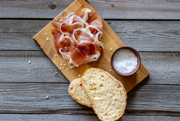 Prosciutto e pane su legno