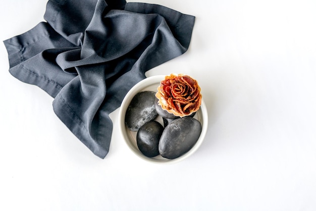 Prosciutto laid out in the form of a flower on black stones