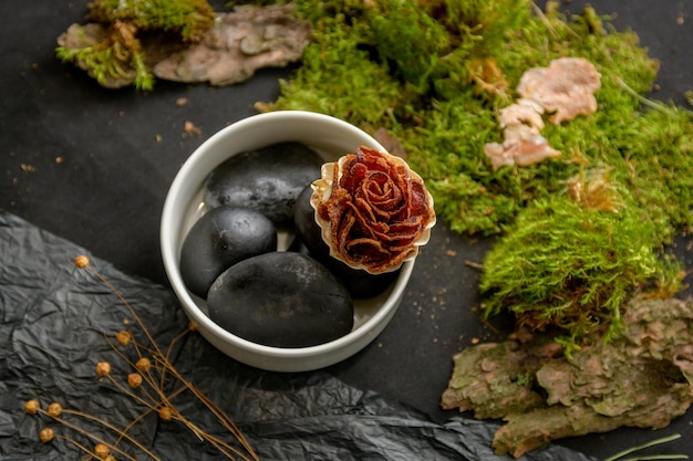 Prosciutto laid out in the form of a flower on black stones