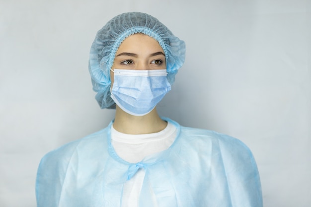 Photo protection against contagious disease, coronavirus. female doctor wearing hygienic face surgical medical mask. banner panorama medical staff preventive gear. studio photo, pandemic