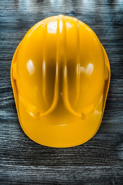 Protective building helmet on wooden board.