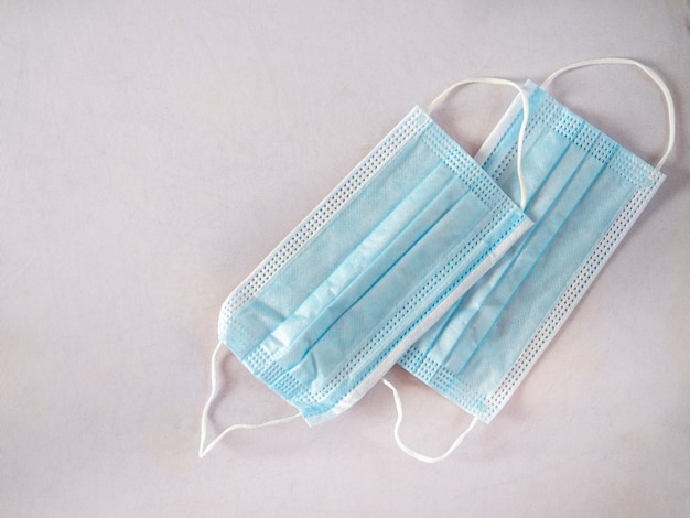 Protective disposable masks of blue color on a white background top view