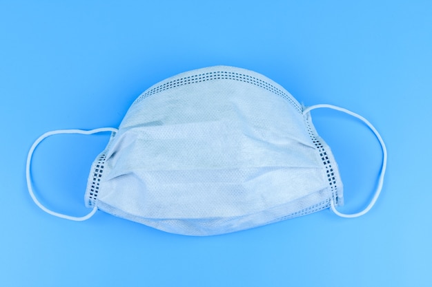 Maschera protettiva su sfondo blu. concetto di sanità e medicina