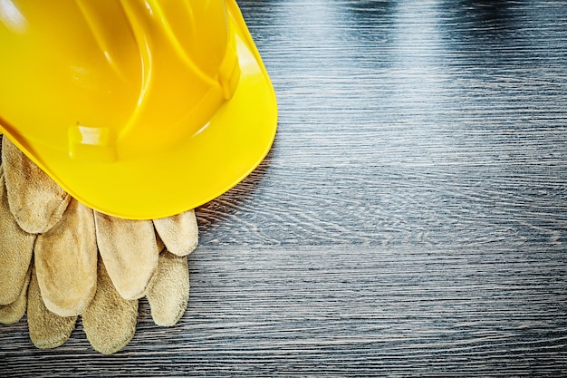 Protective gloves hard hat on wooden board