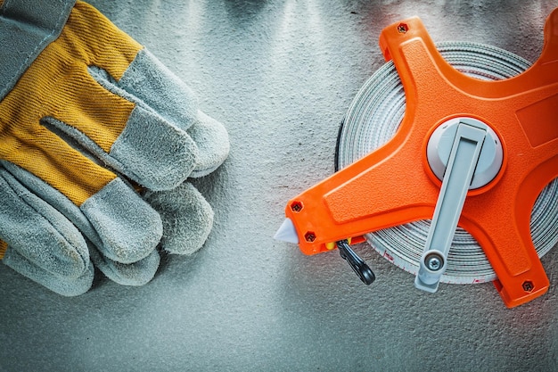 Protective gloves measuring tape on concrete background.