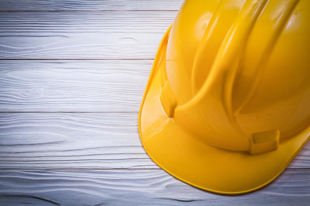 Protective hard hat on wooden board construction concept.